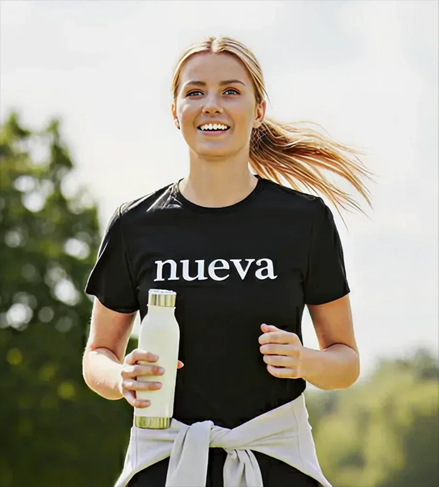 A Nueva Social Marketer out running, holding a drink
